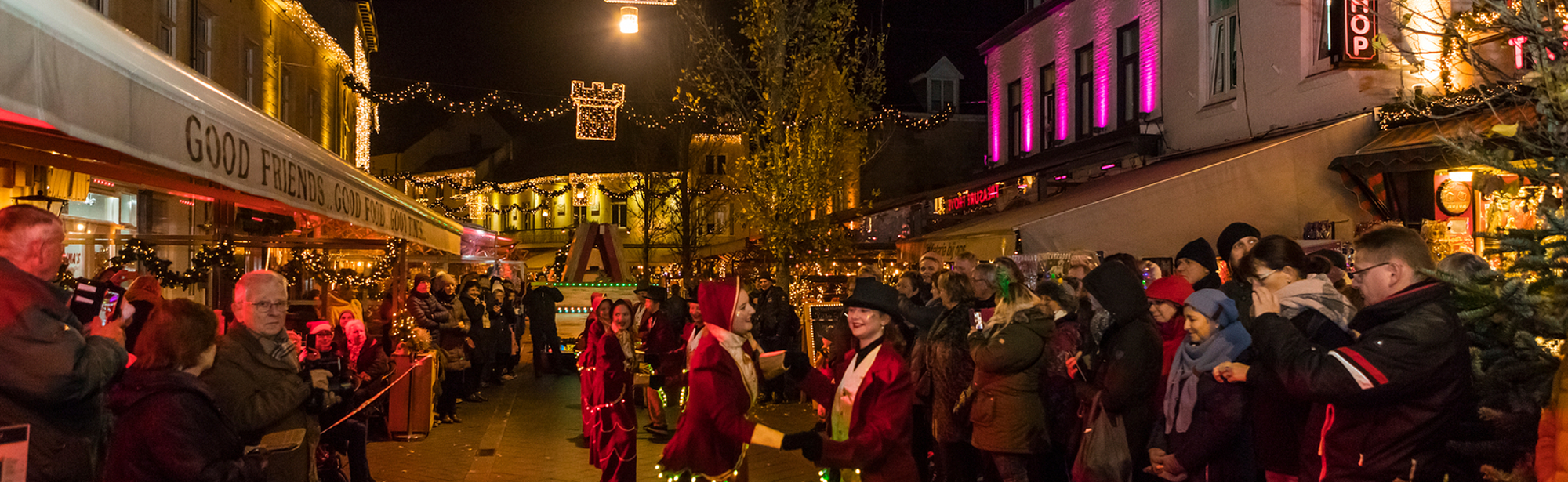 Dansende kinderen in rode kostuums tijdens de kerstparade