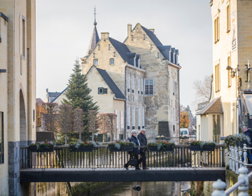 twee oudere mensen lopen over brug bij Geulpoort in de winter