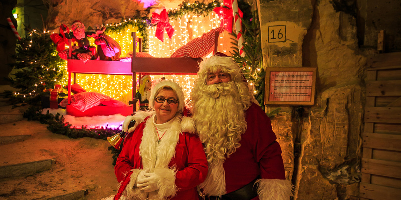 Kerstman en vrouw poseren in mergelgrot