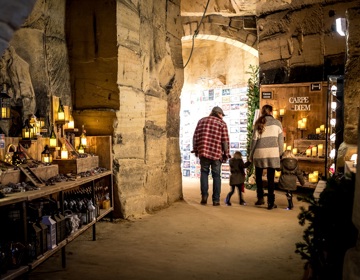 Gezin loopt door gangen tijdens Kerstmarkt Flueweelengrot