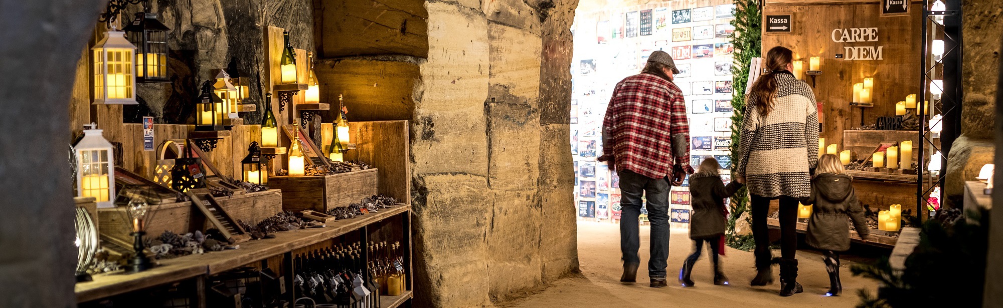 Gezin loopt door gangen tijdens Kerstmarkt Flueweelengrot