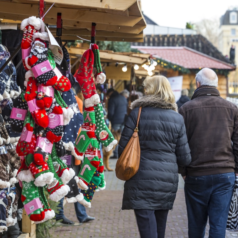 Ouder koppel loopt arm en arm struinend langs de kraampjes van Santa's Village