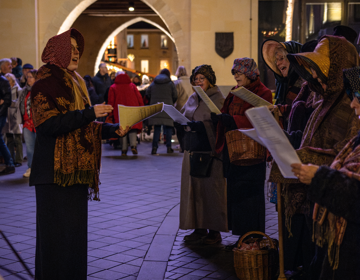 Koor i n Dickens kostuums zingen voor Geulpoort in Valkenburg