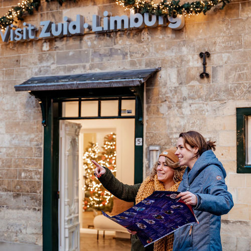 2 vrouwen met uitgevouwen plattegrond voor ingang van Visit Zuid-Limburg